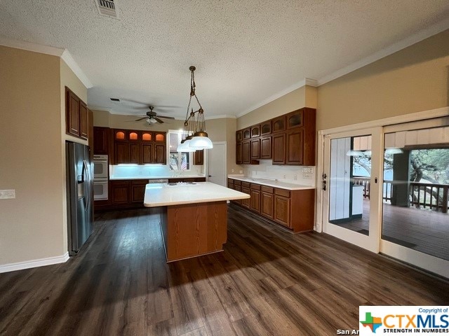 kitchen with pendant lighting, a center island, stainless steel refrigerator with ice dispenser, dark hardwood / wood-style floors, and a textured ceiling