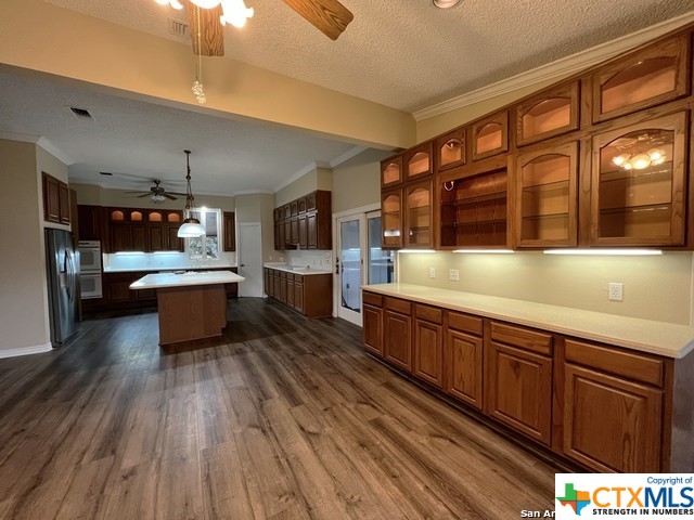 kitchen featuring white oven, a center island, hanging light fixtures, and a textured ceiling