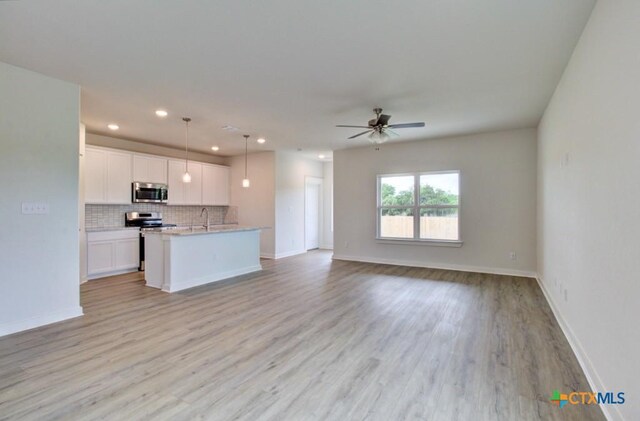 3625 Meteor Rd, New Braunfels, TX 78130 - kitchen with stainless steel appliances, open floor plan, recessed lighting, a ceiling fan, and white cabinets