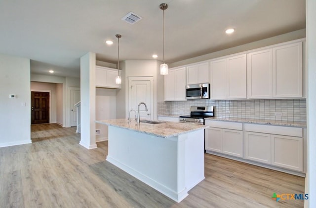 3625 Meteor Rd, New Braunfels, TX 78130 - kitchen featuring appliances with stainless steel finishes, a sink, light wood-style flooring, backsplash, and white cabinets