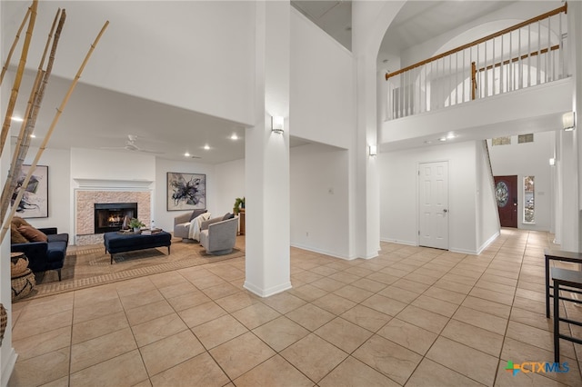 16503 Lounsbury Pl, Austin, TX 78717 - living area with light tile patterned floors, a ceiling fan, a towering ceiling, a warm lit fireplace, and recessed lighting