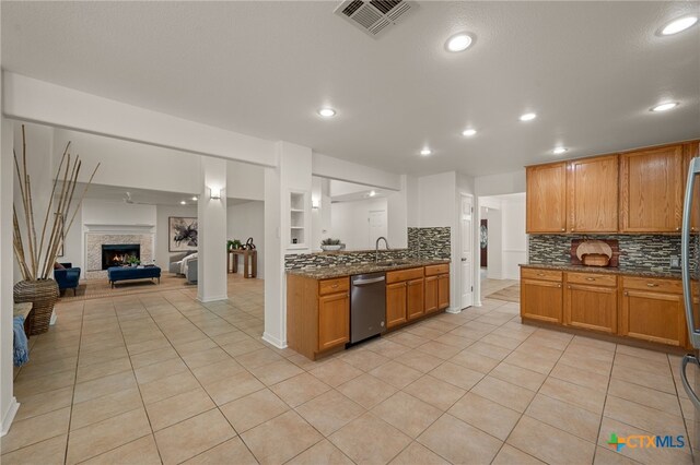 16503 Lounsbury Pl, Austin, TX 78717 - kitchen featuring stainless steel dishwasher, decorative backsplash, light tile patterned floors, dark stone counters, and recessed lighting