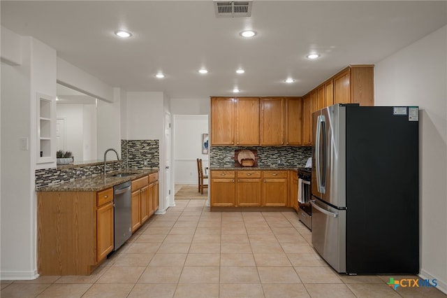 16503 Lounsbury Pl, Austin, TX 78717 - kitchen with stainless steel appliances, decorative backsplash, dark stone countertops, light tile patterned flooring, and recessed lighting