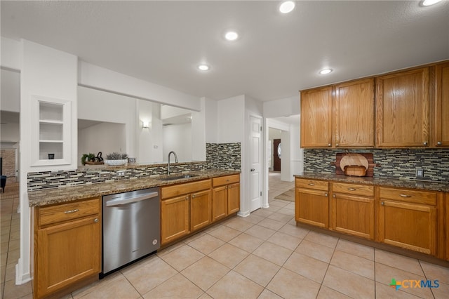 16503 Lounsbury Pl, Austin, TX 78717 - kitchen featuring dishwasher, decorative backsplash, brown cabinetry, light tile patterned floors, and dark stone counters