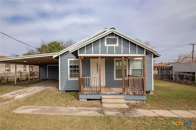 409 E Empresario St, Refugio, TX 78377 - bungalow-style house featuring covered porch, a front yard, fence, an attached carport, and driveway