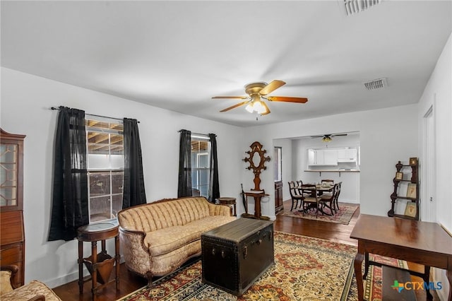 409 E Empresario St, Refugio, TX 78377 - living area featuring dark wood-style floors, baseboards, visible vents, and a ceiling fan