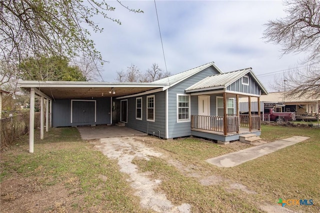 409 E Empresario St, Refugio, TX 78377 - view of front of property featuring an attached carport, covered porch, driveway, and a front yard