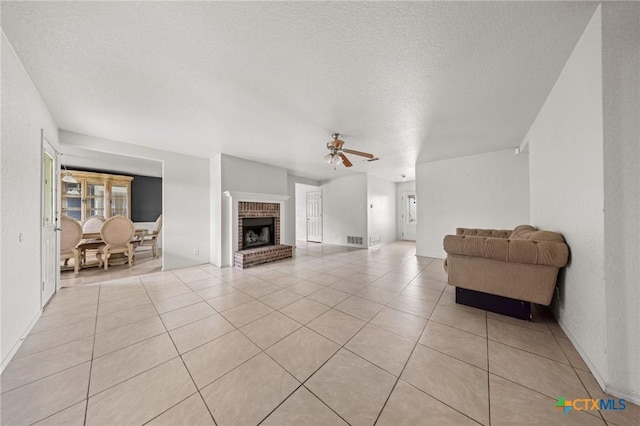 3810 John Haedge Dr, Killeen, TX 76549 - living room with a ceiling fan, a textured ceiling, light tile patterned floors, and a brick fireplace