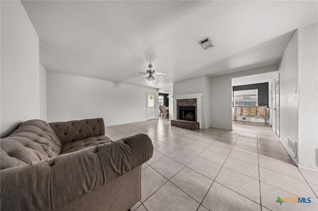3810 John Haedge Dr, Killeen, TX 76549 - living area featuring a ceiling fan, light tile patterned floors, a textured ceiling, and a brick fireplace