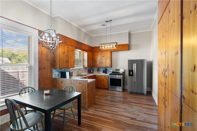 kitchen featuring pendant lighting, kitchen peninsula, stainless steel appliances, and dark wood-type flooring