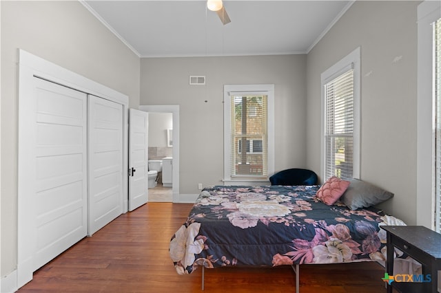 bedroom with ornamental molding, ceiling fan, dark hardwood / wood-style floors, connected bathroom, and a closet