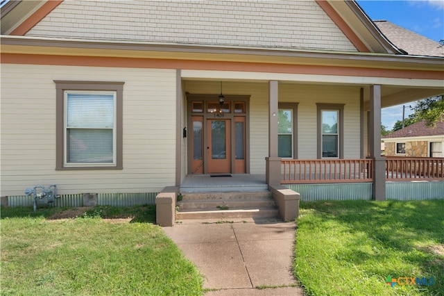 doorway to property with a yard and covered porch