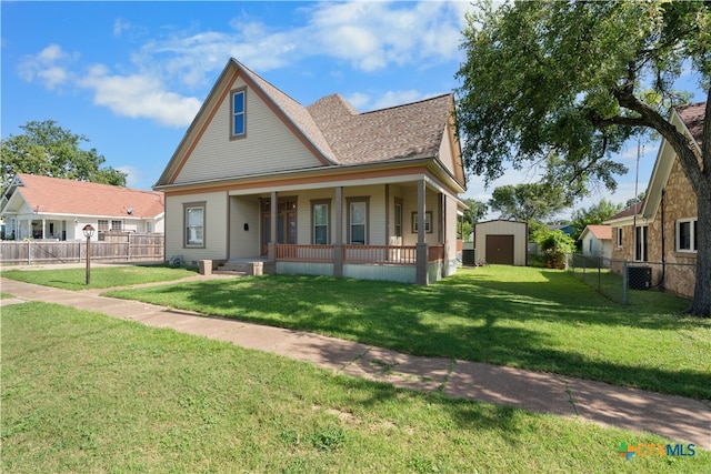 view of front facade with a front lawn, a shed, and covered porch