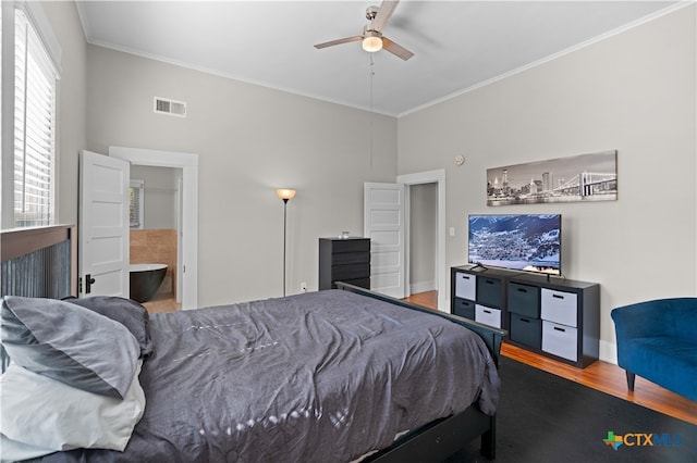 bedroom featuring ornamental molding, connected bathroom, hardwood / wood-style flooring, and ceiling fan