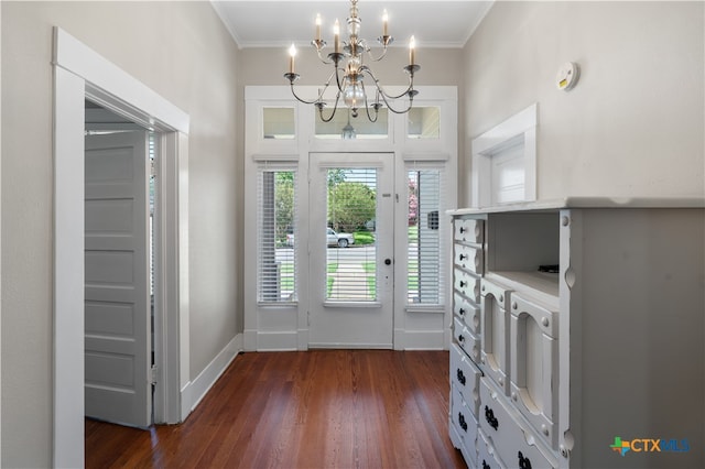 foyer with dark hardwood / wood-style floors, a chandelier, and crown molding