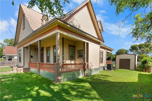 view of side of home with central air condition unit, a porch, a storage unit, and a lawn