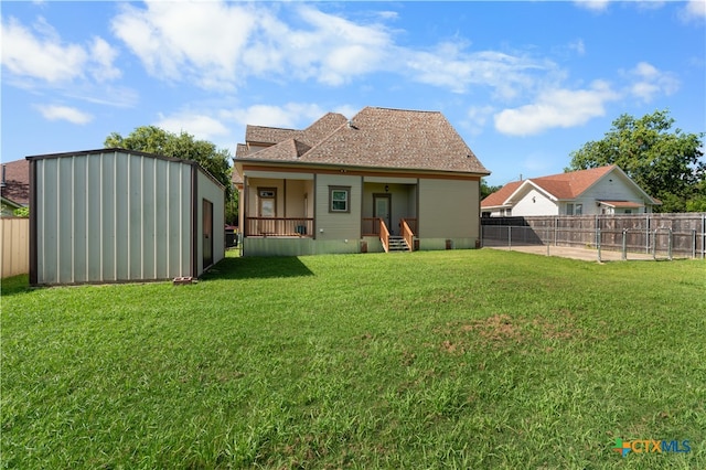 back of property with a yard and covered porch