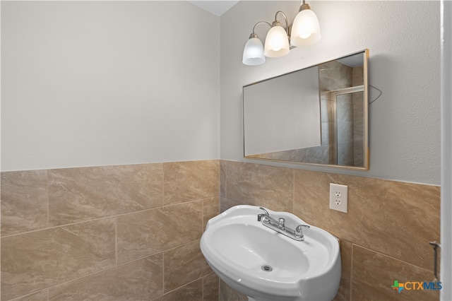 bathroom featuring sink, tile walls, and a notable chandelier