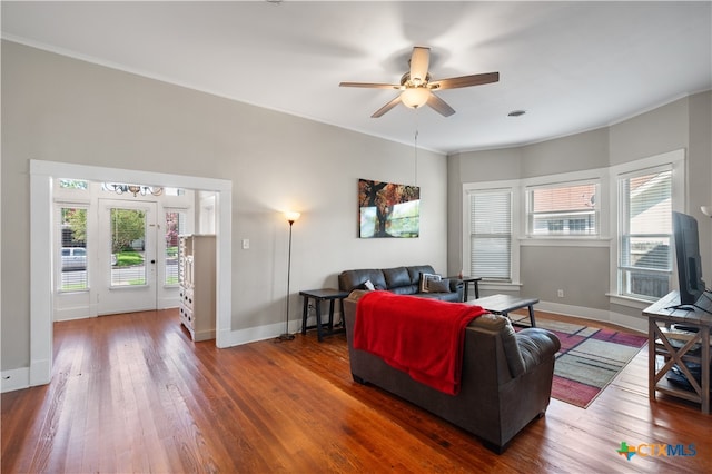 living room featuring ornamental molding, wood-type flooring, and ceiling fan