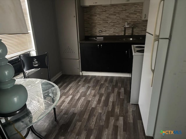 kitchen with dark wood finished floors, range with electric cooktop, a sink, freestanding refrigerator, and decorative backsplash