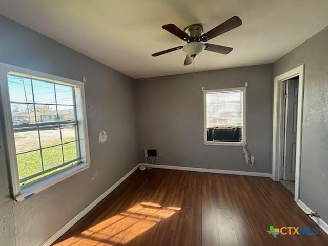 interior space with baseboards, wood finished floors, ceiling fan, and a healthy amount of sunlight