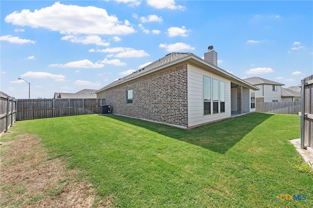 exterior space featuring central AC and a yard