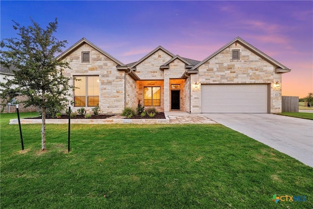 view of front of property with a garage and a lawn