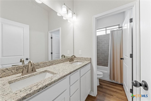 full bathroom with vanity, hardwood / wood-style floors, shower / tub combo with curtain, and toilet