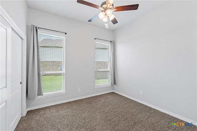 carpeted spare room featuring ceiling fan