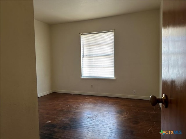 empty room with dark hardwood / wood-style flooring