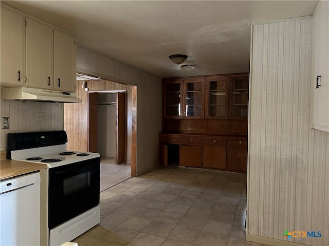 kitchen featuring electric range oven, dishwasher, and wood walls