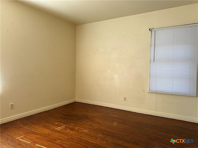 empty room with dark hardwood / wood-style flooring