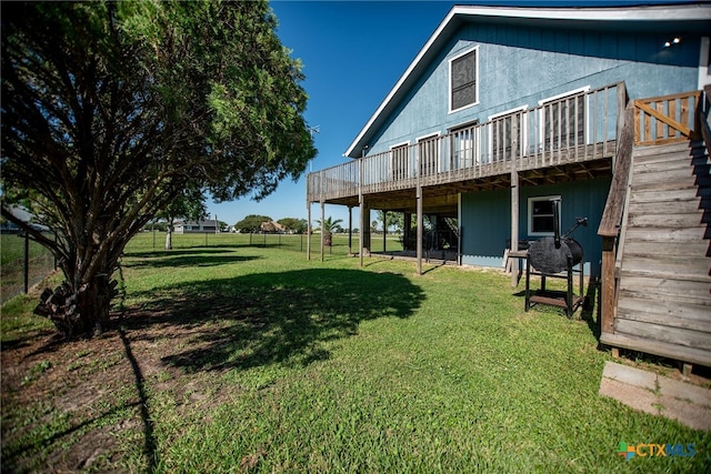 rear view of house featuring a yard and a deck