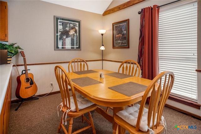 carpeted dining area with lofted ceiling