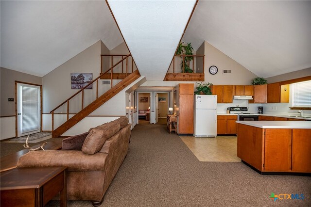 kitchen featuring black electric range oven, sink, high vaulted ceiling, and white refrigerator