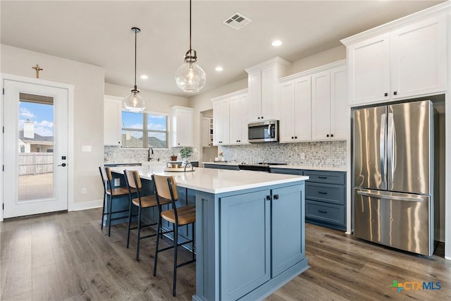 837 Gallant Fox Rd, Hewitt, TX 76643 - kitchen with stainless steel appliances, dark wood-type flooring, white cabinets, a kitchen island, and recessed lighting
