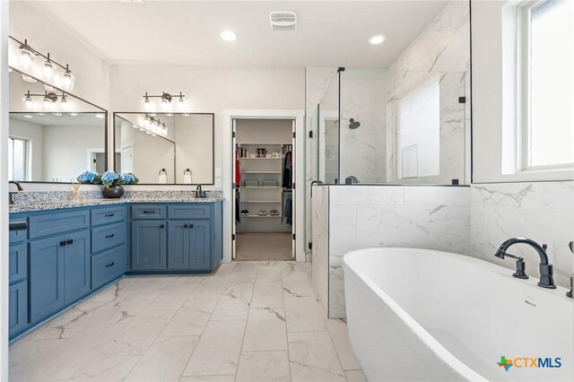 837 Gallant Fox Rd, Hewitt, TX 76643 - bathroom featuring a walk in closet, a marble finish shower, double vanity, a freestanding bath, and marble finish flooring