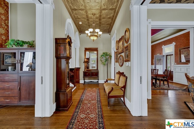 corridor with dark hardwood / wood-style floors, a healthy amount of sunlight, and crown molding