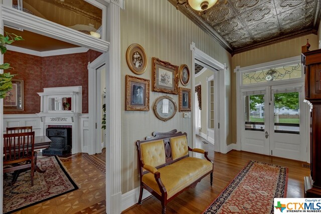 living area featuring french doors, parquet floors, and crown molding