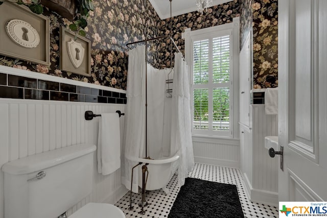 bathroom with crown molding, shower / bath combo, and toilet