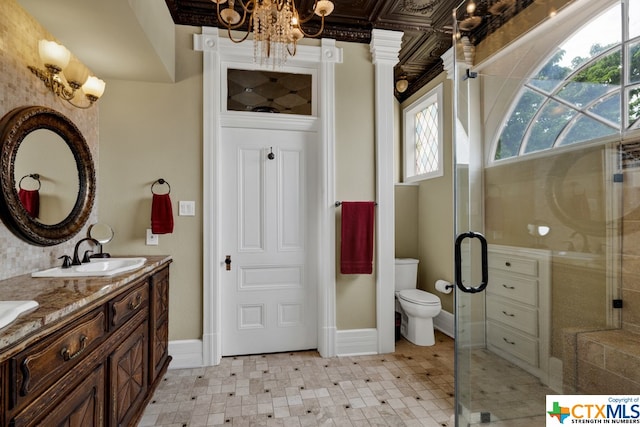 bathroom with toilet, an enclosed shower, vanity, and an inviting chandelier