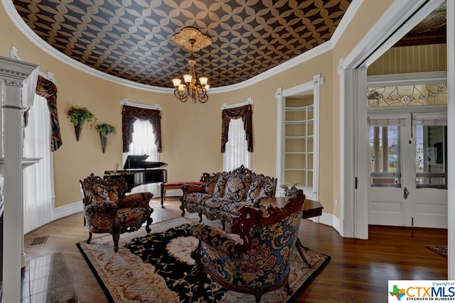 living room with dark wood-type flooring, a wealth of natural light, a chandelier, and ornamental molding