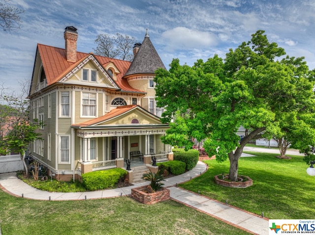 victorian-style house featuring a front yard and covered porch