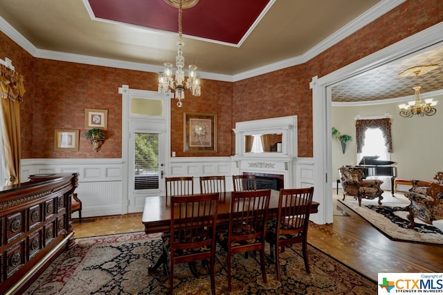 dining space featuring ornamental molding, a wealth of natural light, and hardwood / wood-style flooring