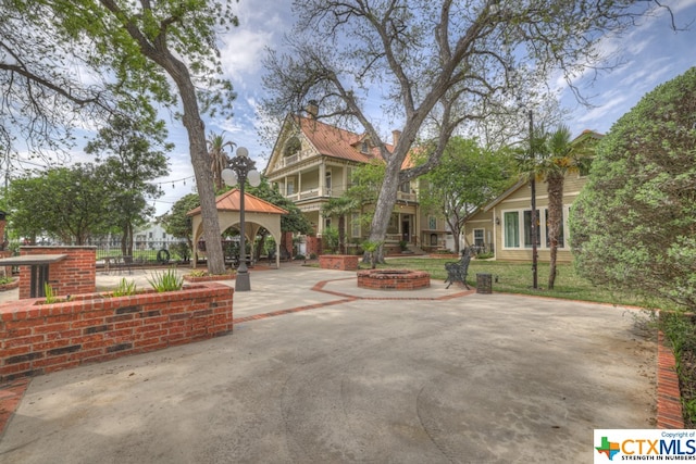 view of front of house with a patio, a gazebo, and a fire pit