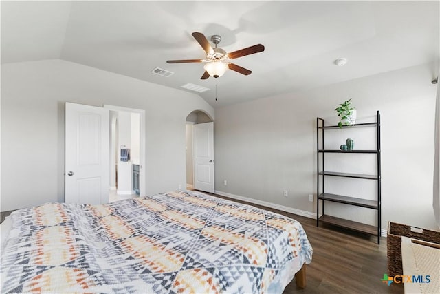 bedroom featuring lofted ceiling, wood finished floors, arched walkways, and visible vents