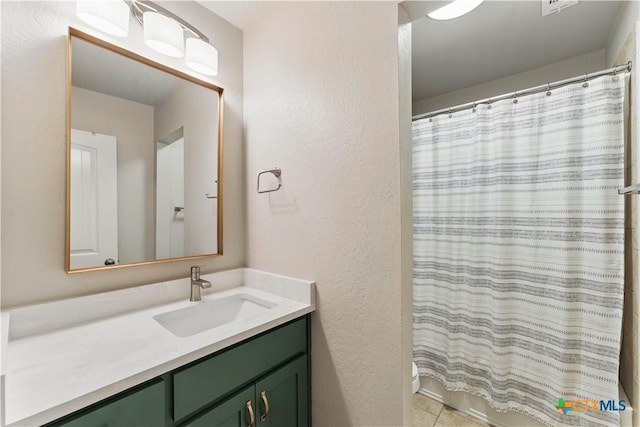 full bathroom featuring vanity and a textured wall