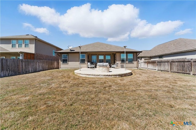 rear view of house featuring a patio, a yard, and a fenced backyard