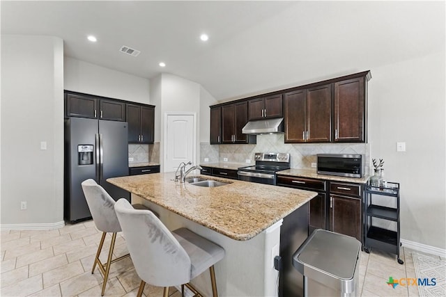 kitchen featuring visible vents, under cabinet range hood, a breakfast bar, stainless steel appliances, and a sink