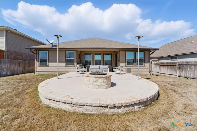 rear view of house with a patio, a fenced backyard, a lawn, and an outdoor fire pit